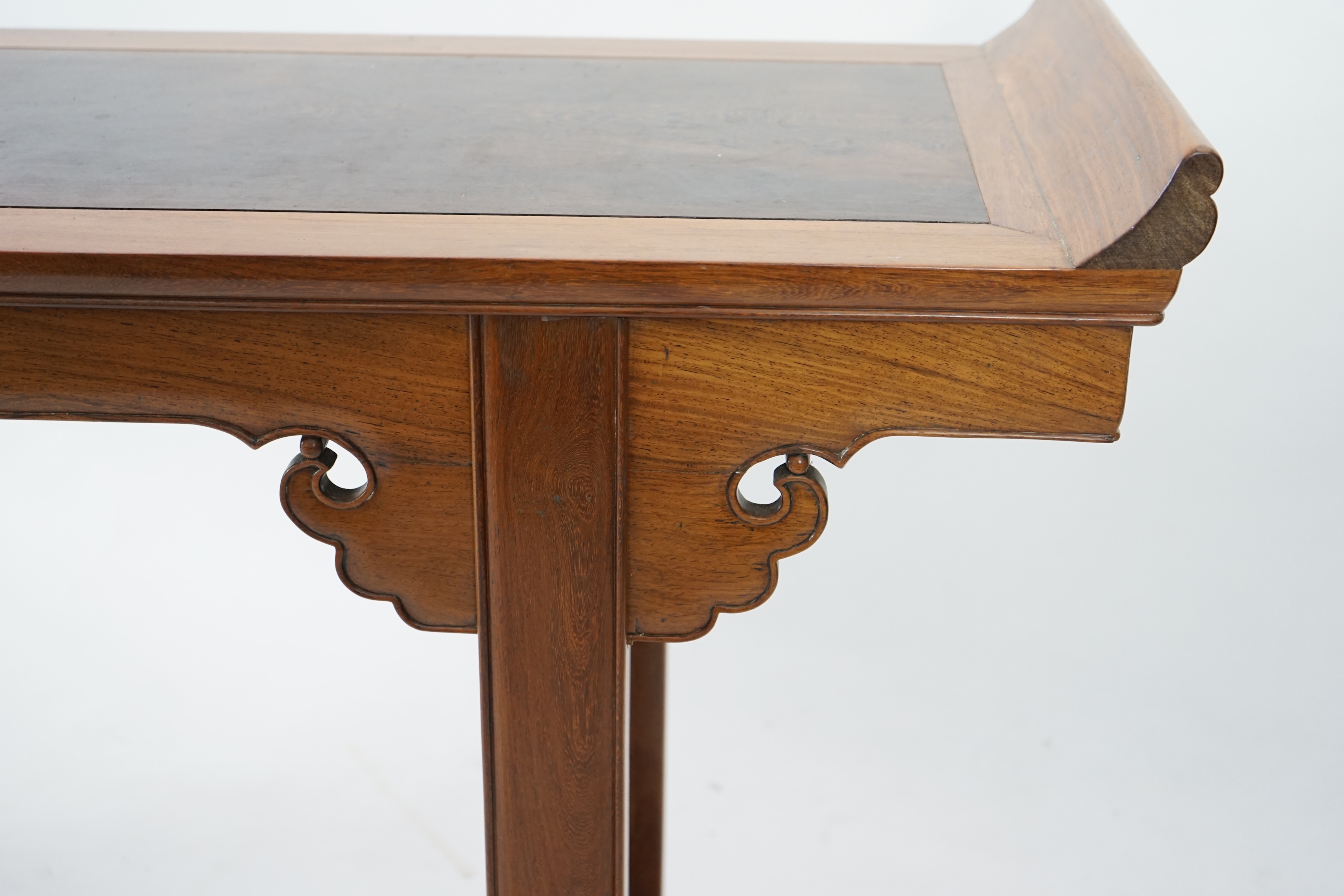 A Chinese padouk wood and jichimu altar table, the panelled rectangular top with scroll ends, on plain uprights headed by ruyi, 185cm wide, 94cm high. Condition - fair to good